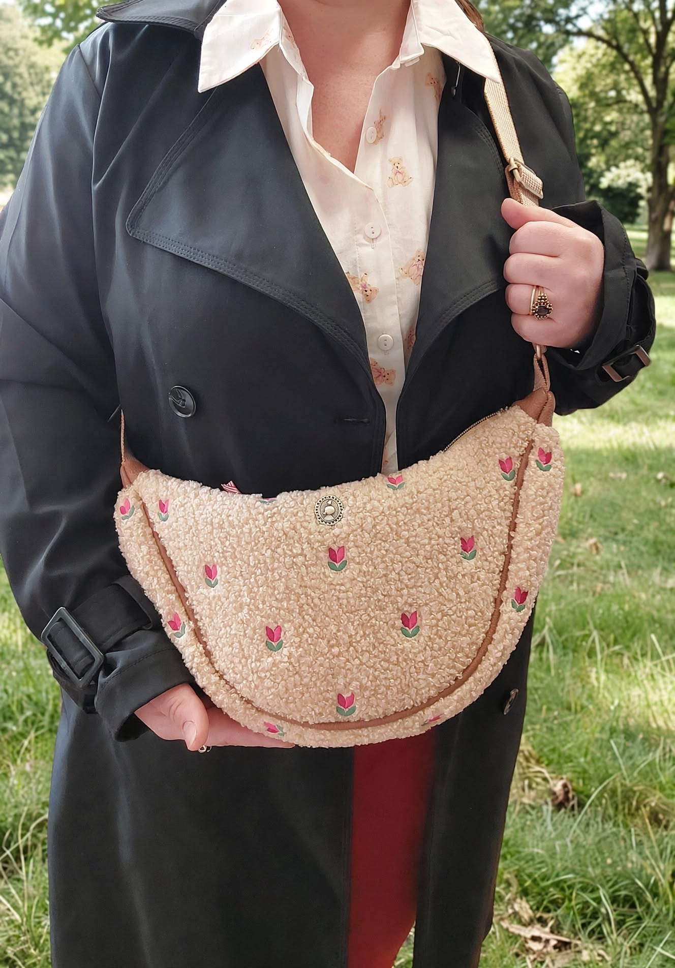 Pip Studio Freya Half Moon Cross Body Teddy Sand kabelka, písková na modelce v černém kabátu a světlé košili s medvídky v přírodě